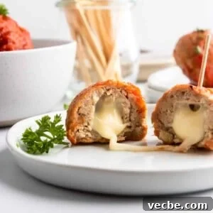 Mozzarella Stuffed Turkey Meatballs Recipe 8 Mozzarella stuffed turkey meatballs on plate with cheese stretching.