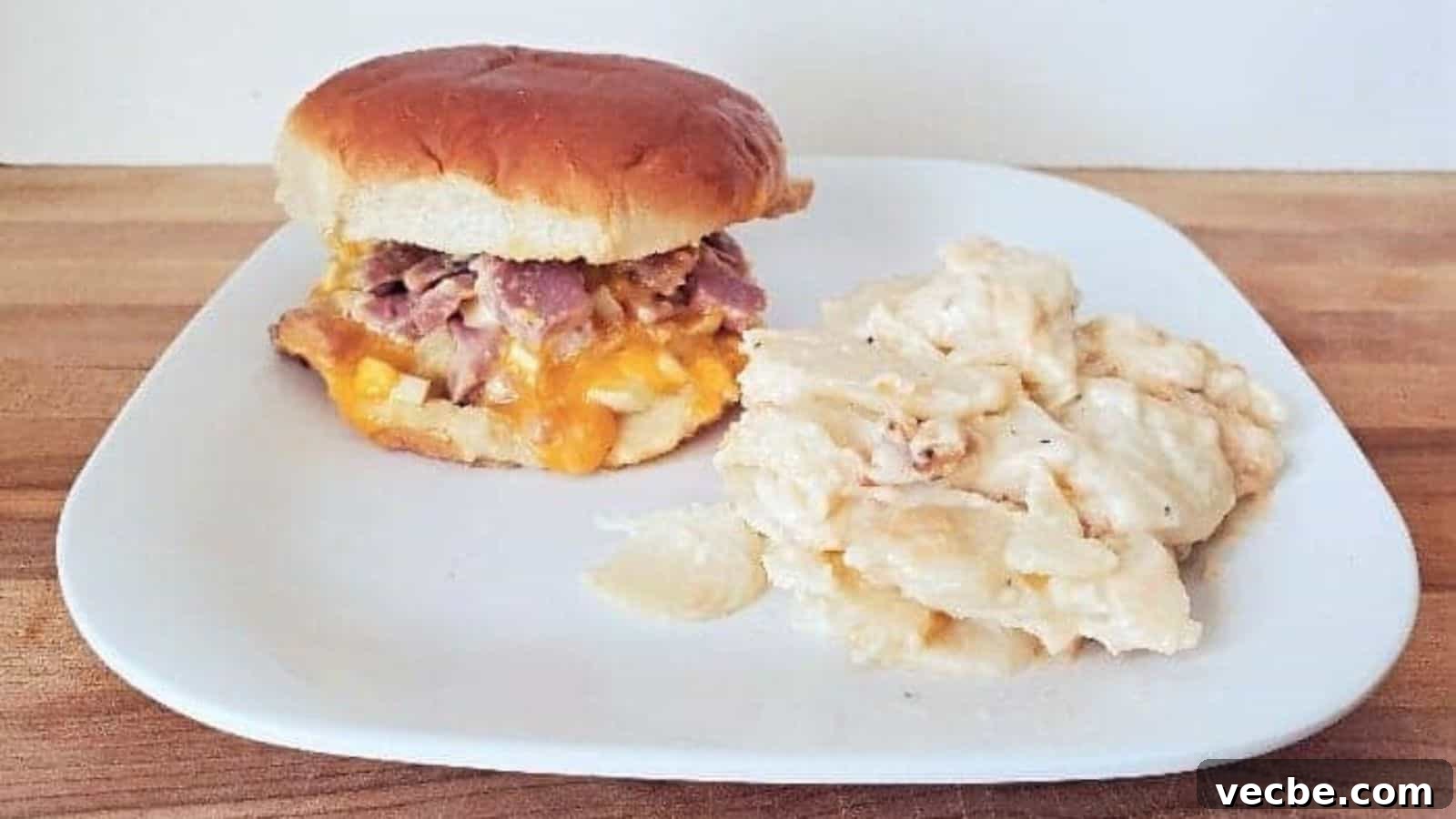 19 Budget-Friendly Meals to Replace Takeout 13 Image shows a white plate with a hot ham salad sandwich and scalloped potatoes.
