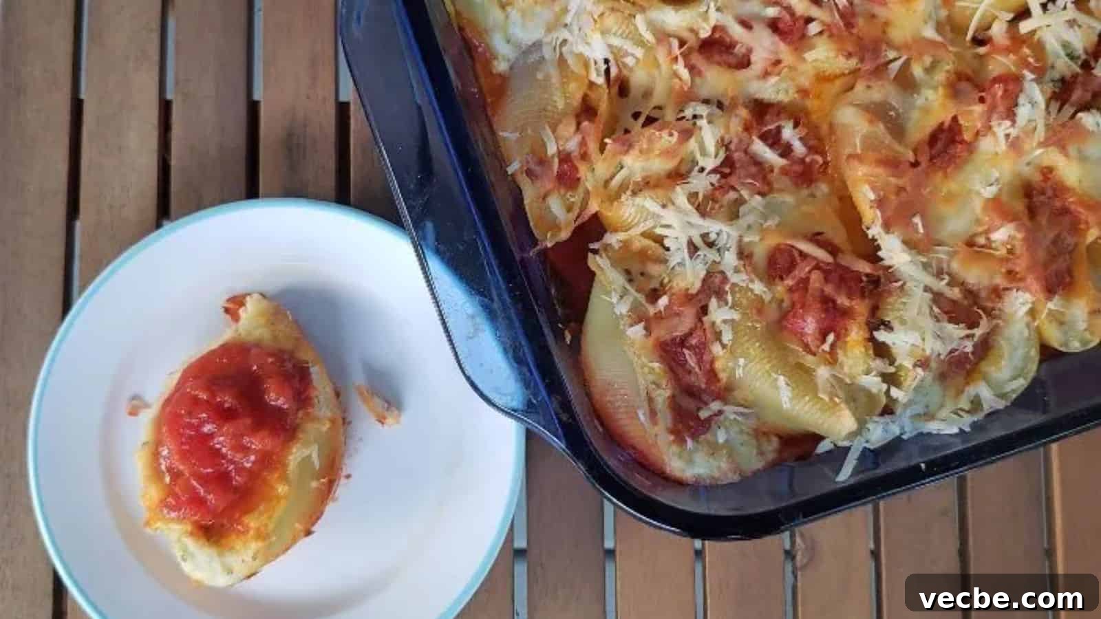 19 Budget-Friendly Meals to Replace Takeout 15 Image shows an overhead shot of Easy Cheesy Stuffed Shells with a small plate holding one and the rest of the pan next to it.