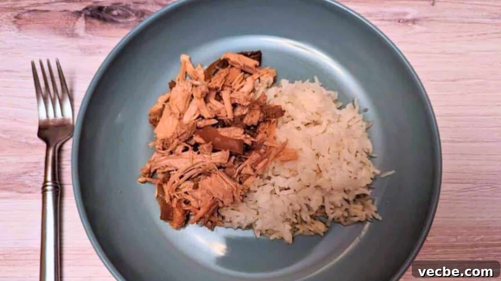 19 Budget-Friendly Meals to Replace Takeout 19 Image shows an overhead shot of Slow Cooker Garlic Roast Pork on a blue plate served with rice.