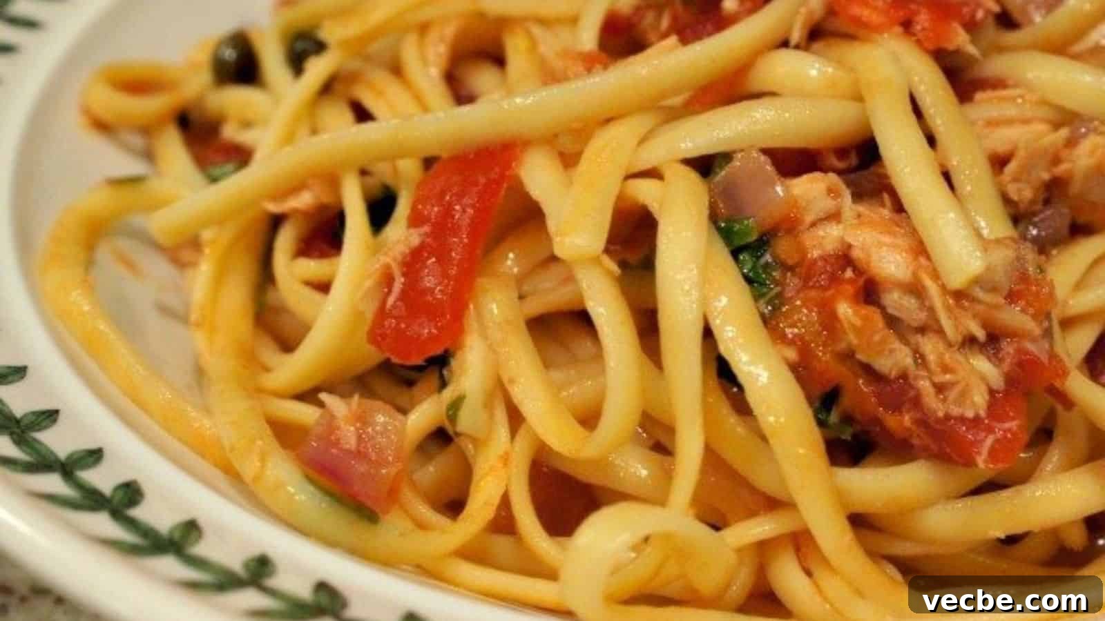 19 Budget-Friendly Meals to Replace Takeout 21 Image shows a closeup view of tuna and tomato pasta in a white patterned bowl.