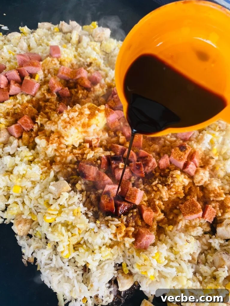 Blackstone Cajun Fried Rice Recipe 6 adding the soy sauce to the rice