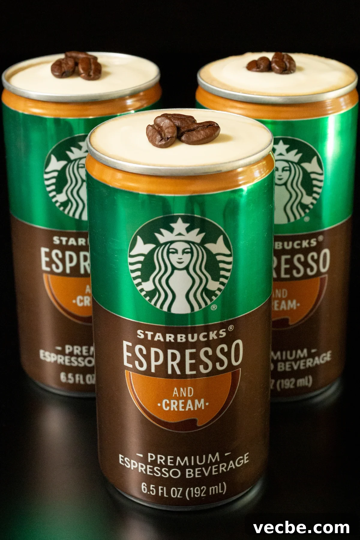 Canned Espresso Martini Cocktail 2 Three open cans of Starbucks Espresso and Cream topped with cold foam and three espresso beans.
