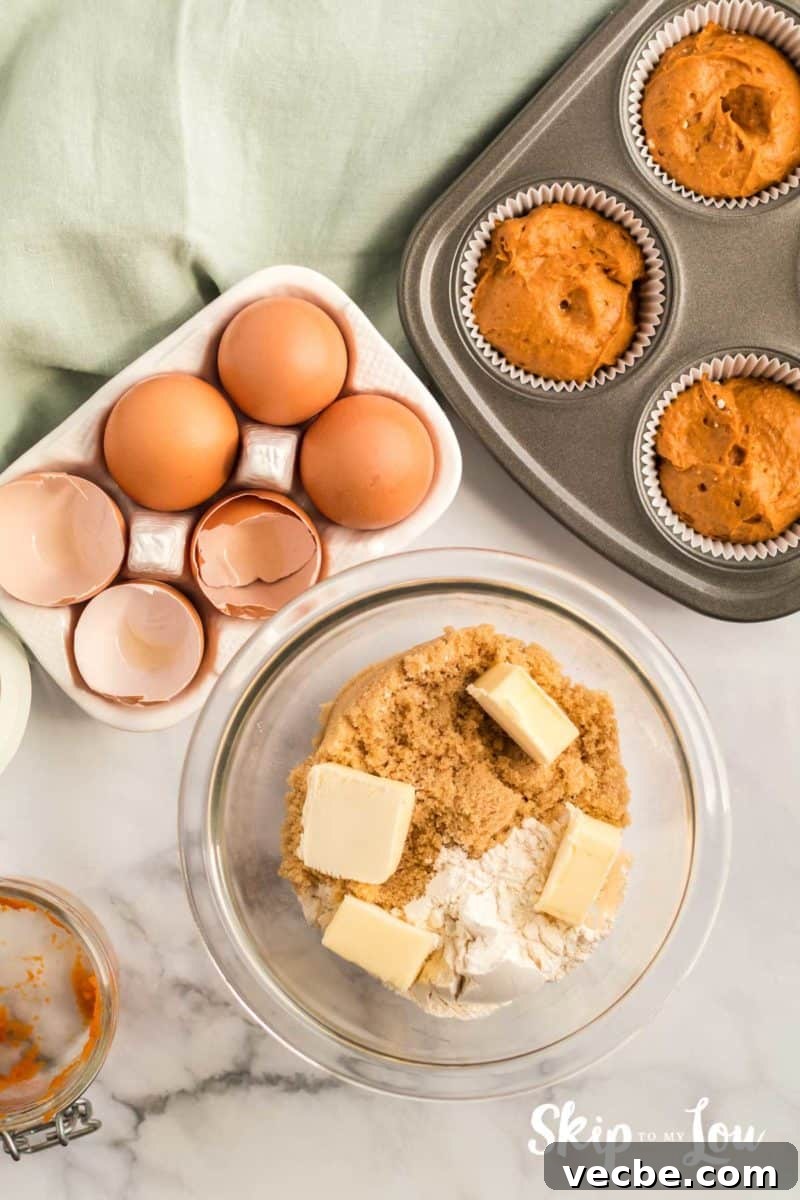 Pumpkin Cake Mix Muffins Recipe 7 streusel topping ingredients - flour, brown sugar and butter place in a small mixing bowl with a muffin tin and muffin batter set to the side waiting for streusel to be added