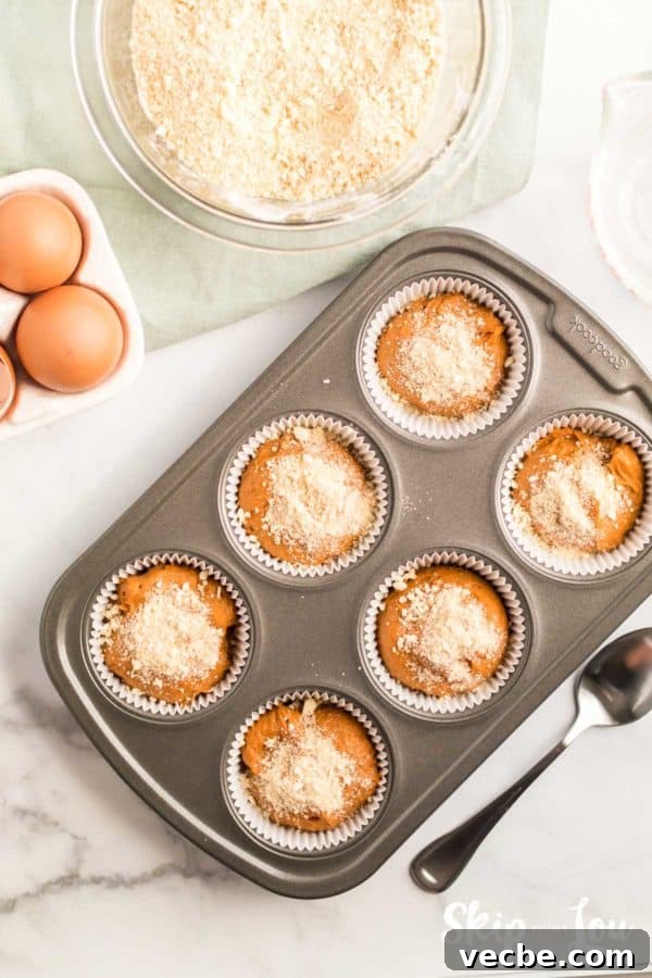 Pumpkin Cake Mix Muffins Recipe 8 streusel topping on uncooked pumkin muffins ready to go into the oven