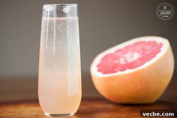 Sparkling Grapefruit Mimosa Recipe for Brunch 4 glass of grapefruit champagne cocktail with half of a pink grapefruit in background
