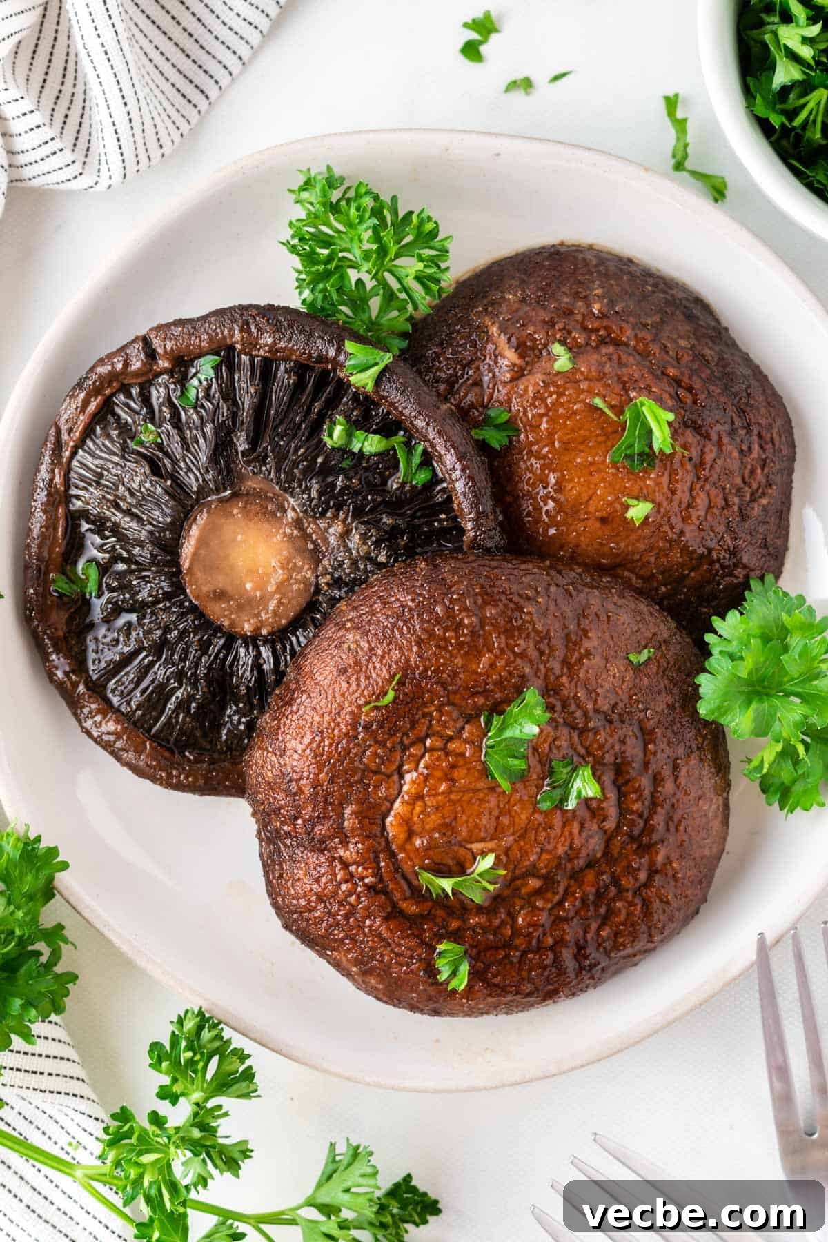 Crispy Air Fryer Portobello Mushrooms Recipe 2 portobello mushrooms topped with parsley on a plate