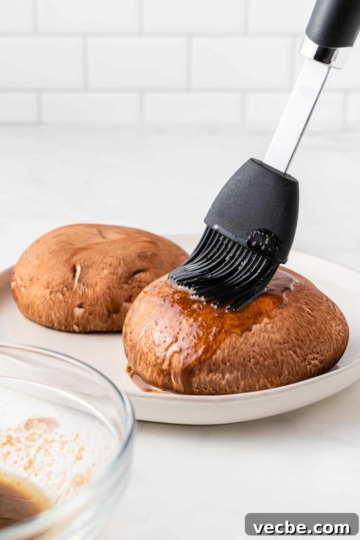 Crispy Air Fryer Portobello Mushrooms Recipe 5 using a basting brush to cover the mushrooms in liquid