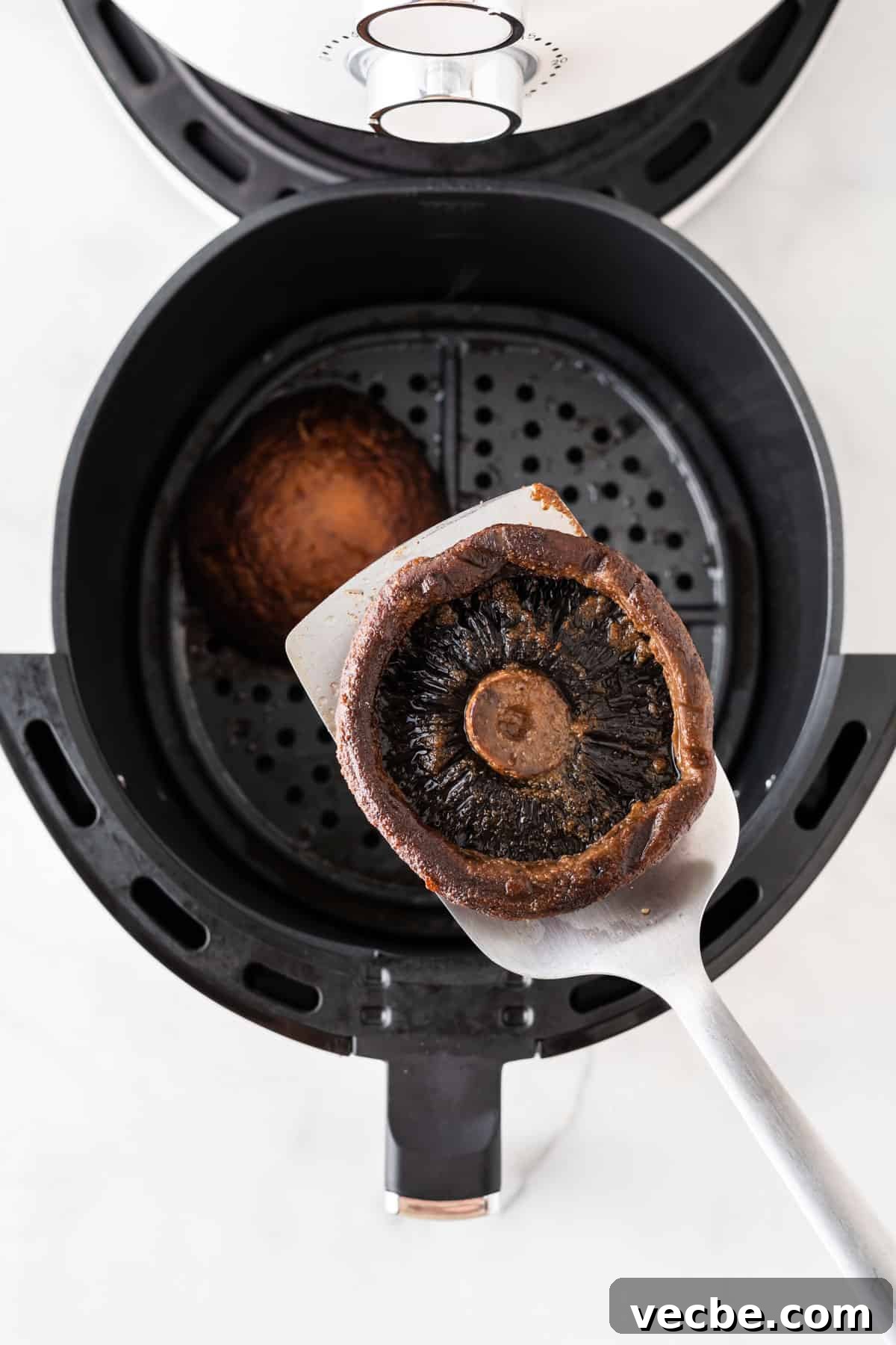 Crispy Air Fryer Portobello Mushrooms Recipe 8 taking a mushroom from the air fryer