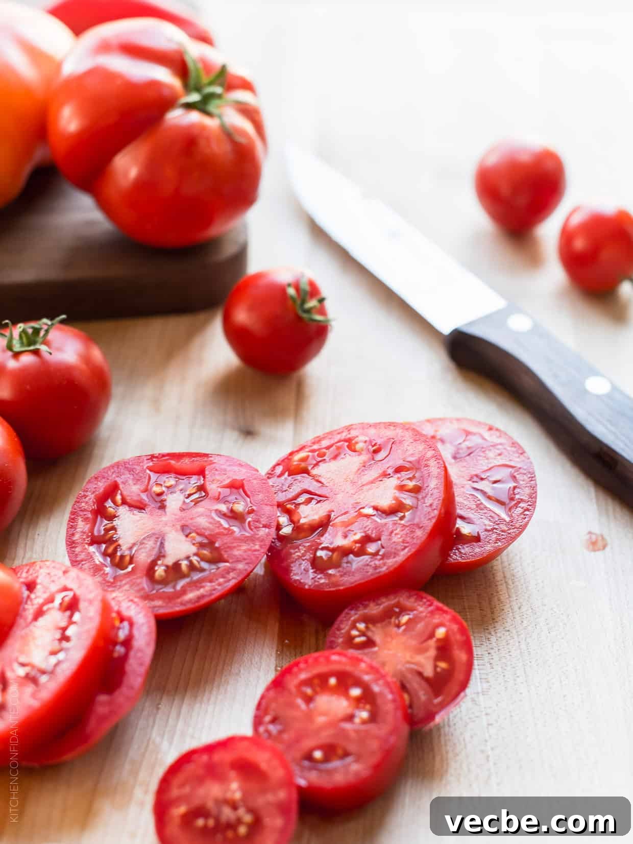 Rustic Tomato and Ricotta Galette Recipe 4 Sliced ingredients on a cutting board with a knife.