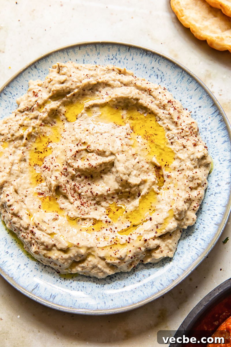 Smoky Baba Ganoush Recipe with Sumac 2 top down view of baba ganoush spread on blue plate