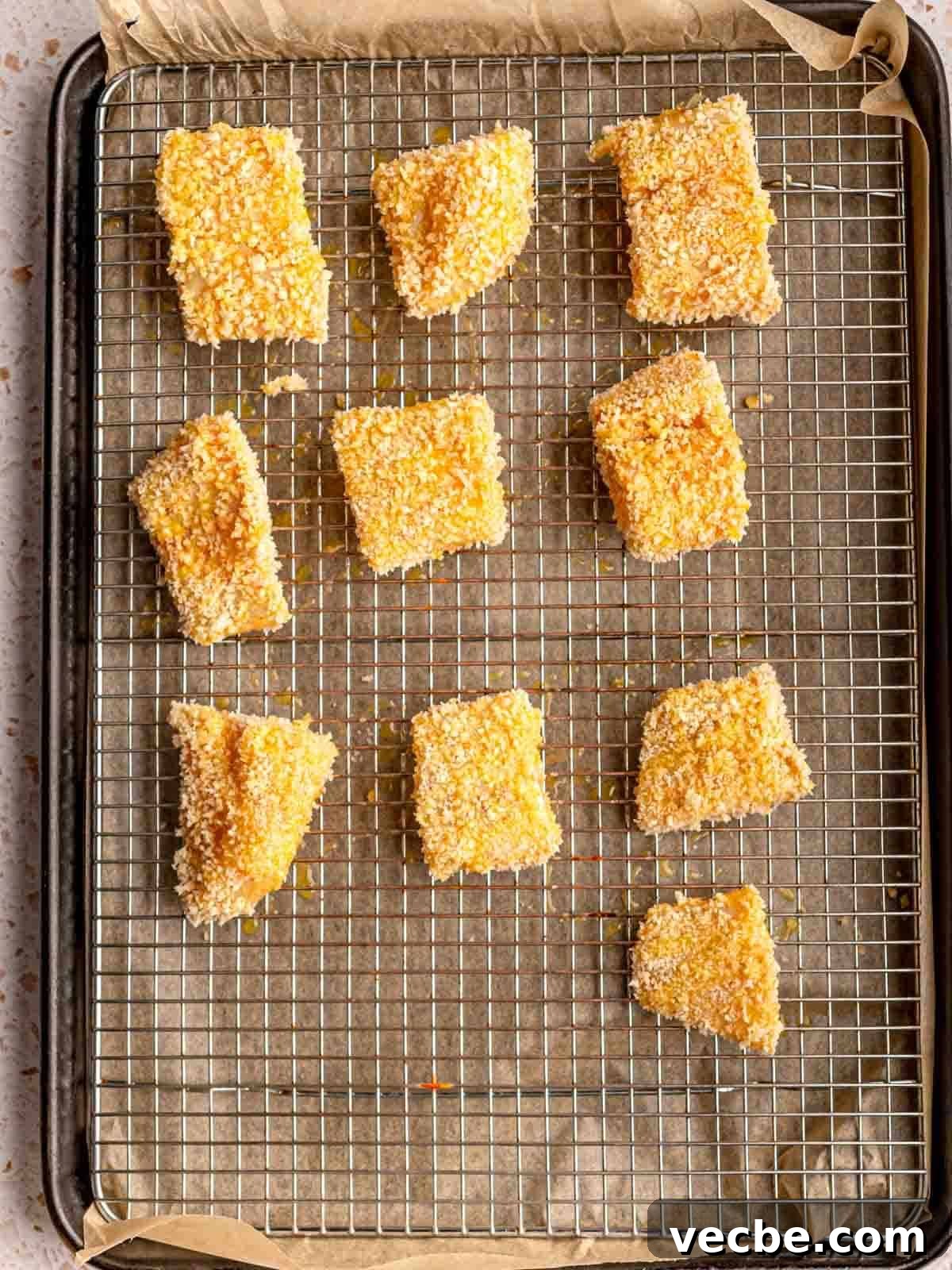 Crispy Fish Tacos with Fresh Mango Salsa Recipe 8 Breaded fish pieces on a baking sheet.