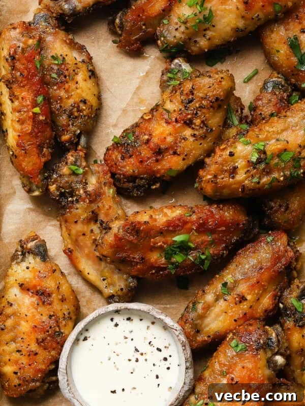 Yogurt-Marinated Grilled Chicken Skewers Recipe 11 Crispy lemon pepper wings on parchment with dipping sauce garnished with herbs.