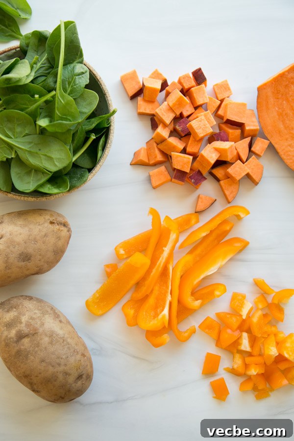 30-Minute Low FODMAP Breakfast Hash Recipe 3 low fodmap hash ingredients on a counter: spinach, sweet potato, regular potato, bell pepper