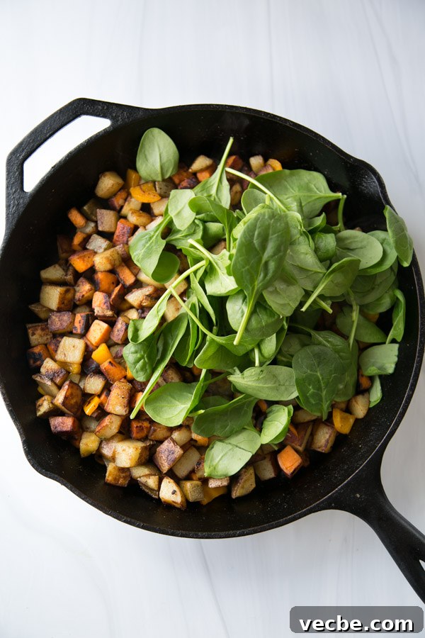 30-Minute Low FODMAP Breakfast Hash Recipe 9 skillet with low fodmap breakfast hash and fresh spinach leaves on top
