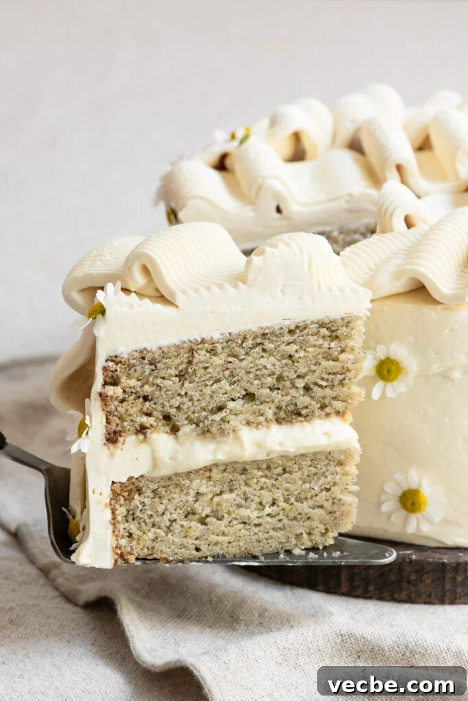 Moist Banana Layer Cake with Honey Buttercream Recipe 2 Slice of two layer banana cake being held on a pie server.