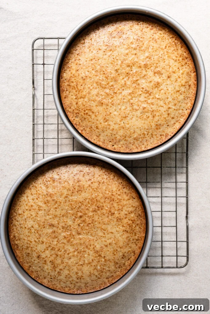 Moist Banana Layer Cake with Honey Buttercream Recipe 12 Overhead of two cakes in their pans on a cooling rack.