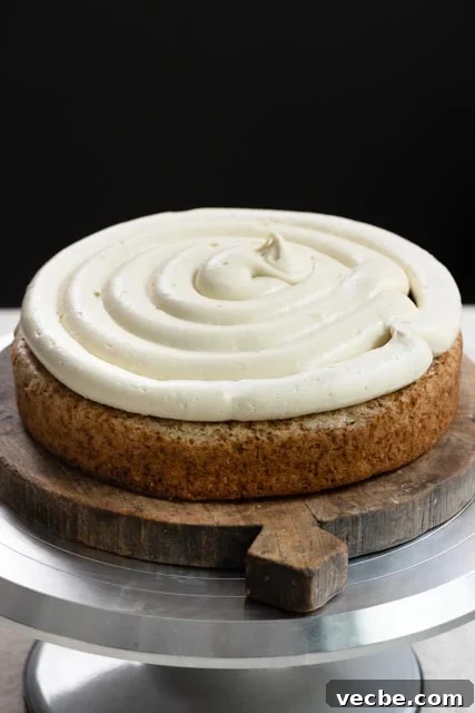 Moist Banana Layer Cake with Honey Buttercream Recipe 13 Single layer of banana cake on turntable, topped with frosting and banana cream filling.