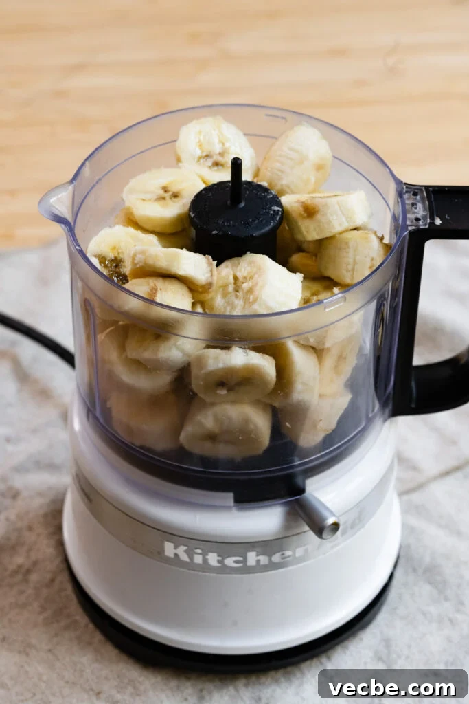 Moist Banana Layer Cake with Honey Buttercream Recipe 4 Sliced bananas in a mini food processor.
