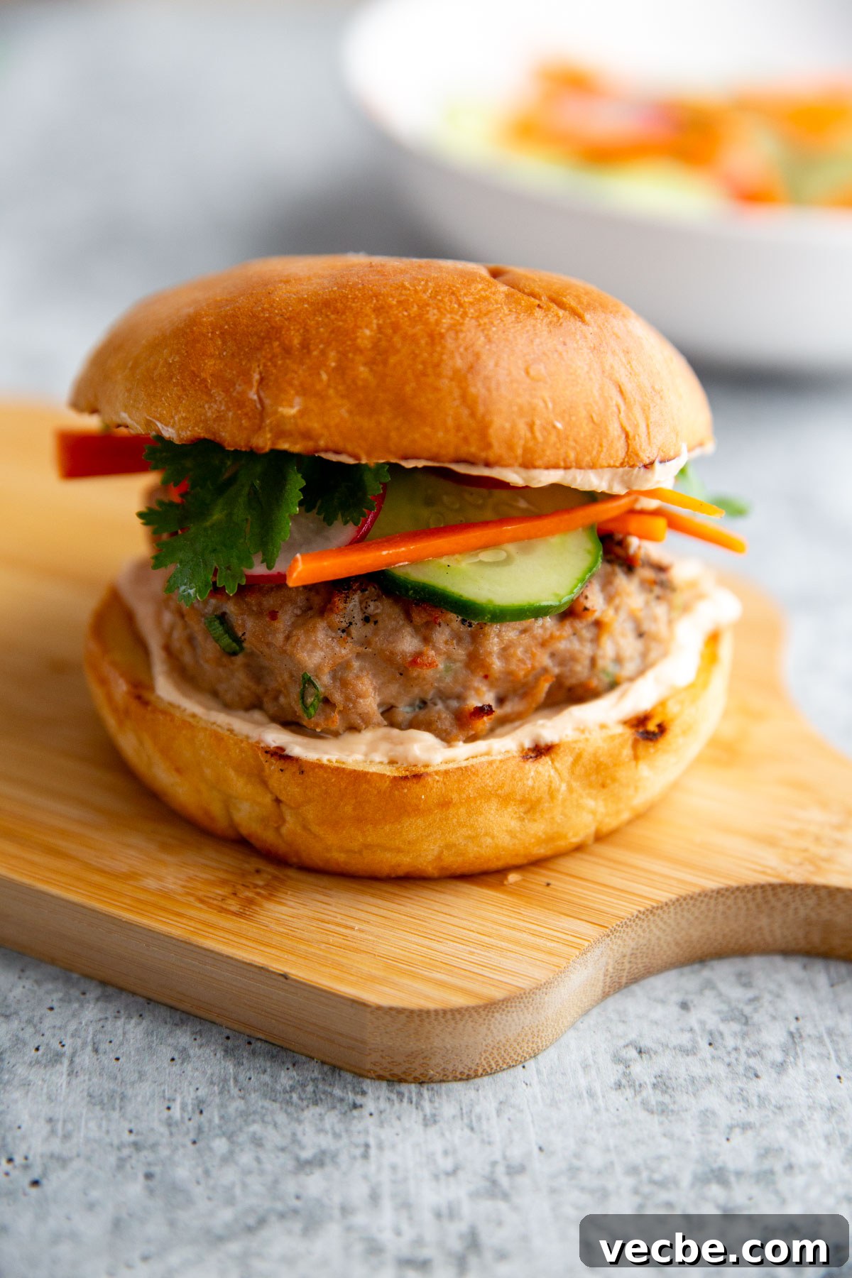 Banh Mi Burger Recipe with Sriracha Cream Cheese 3 a burger on a cutting board