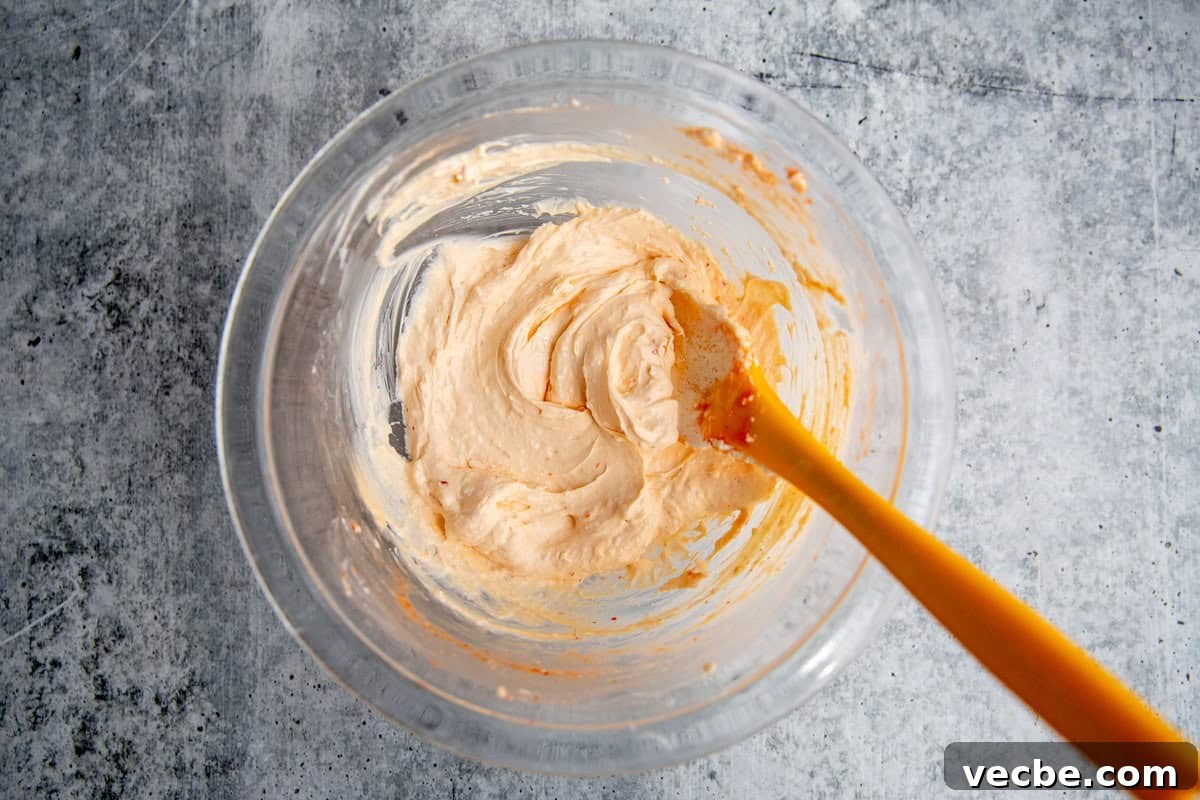 Banh Mi Burger Recipe with Sriracha Cream Cheese 6 sriracha cream cheese spread in a glass bowl with a rubber spatula