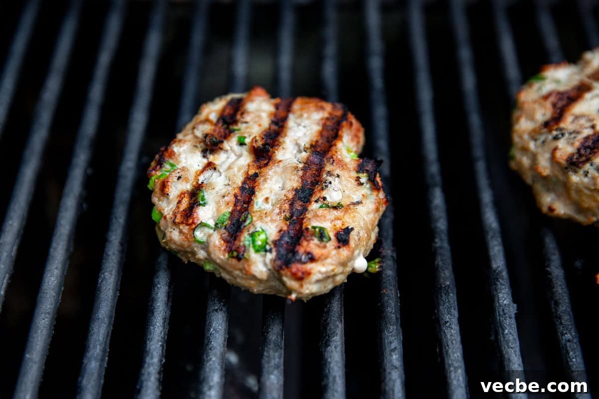 Banh Mi Burger Recipe with Sriracha Cream Cheese 7 a burger with grill marks on a grill