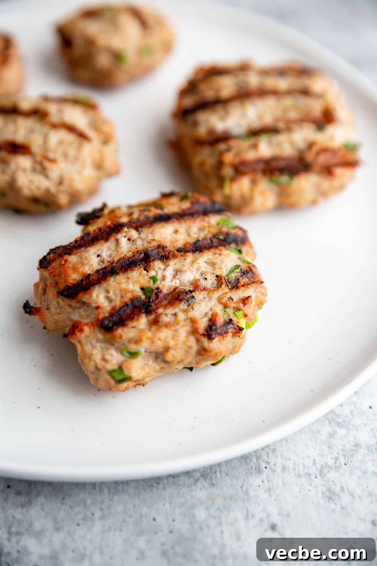 Banh Mi Burger Recipe with Sriracha Cream Cheese 8 grilled banh mi burgers on a white serving plate