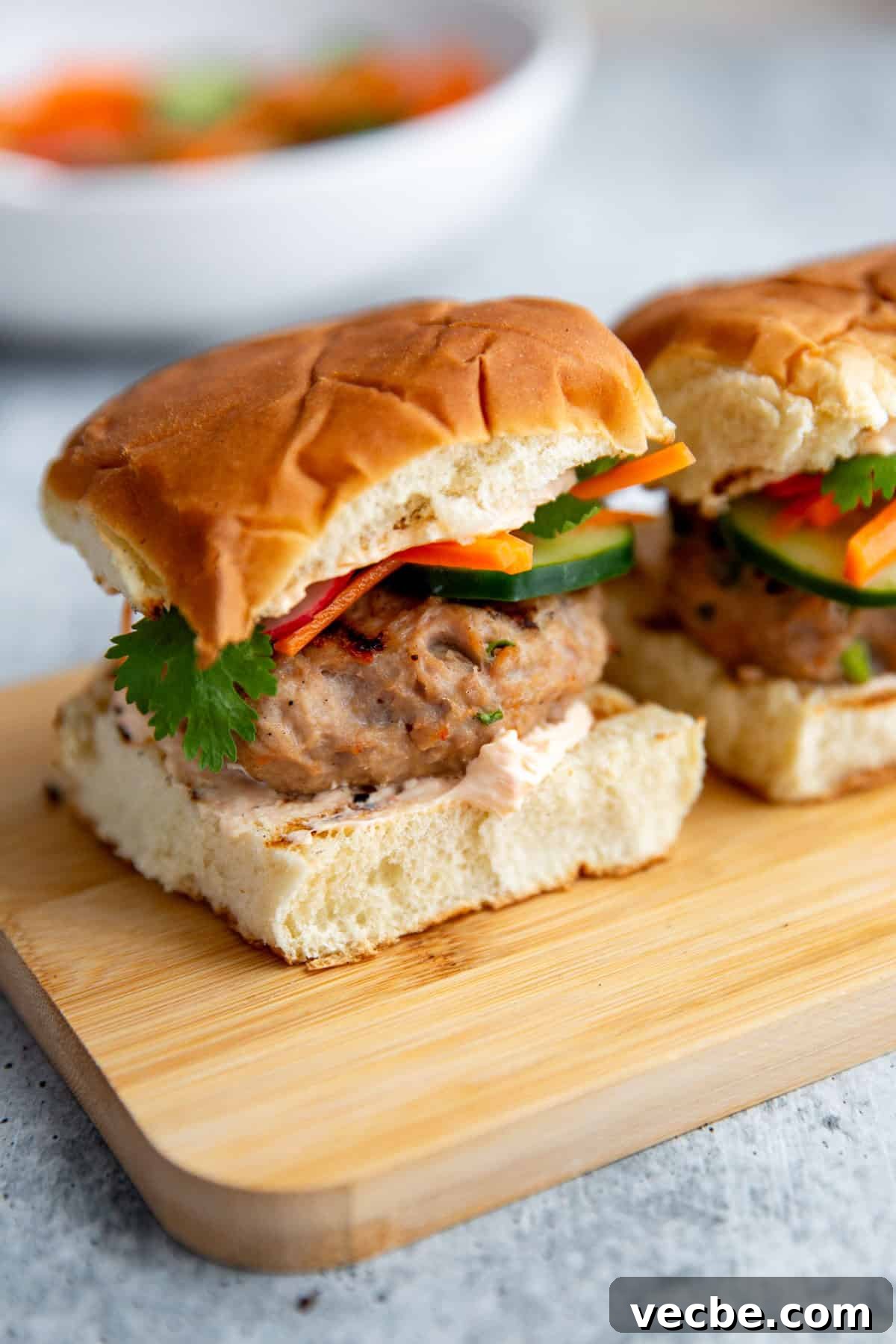Banh Mi Burger Recipe with Sriracha Cream Cheese 9 two sliders on a cutting board