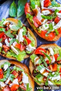 Mini Caprese Avocado Toast Overhead shot of caprese avocado toast on a blue counter.