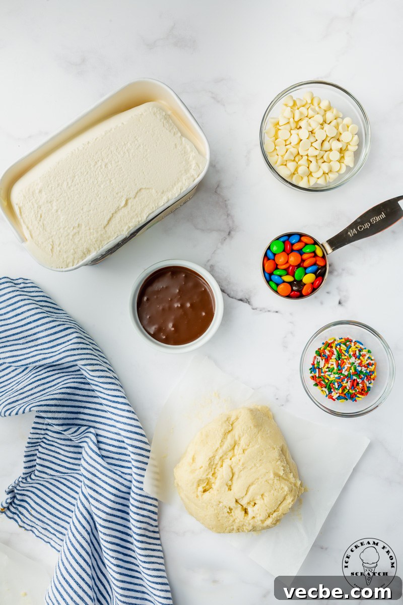 No-Bake Ice Cream Pizza Recipe with Cookie Crust 3 The ingredients needed to make ice cream pizza, including sugar cookie dough, fudge, white chocolate chips, and sprinkles.
