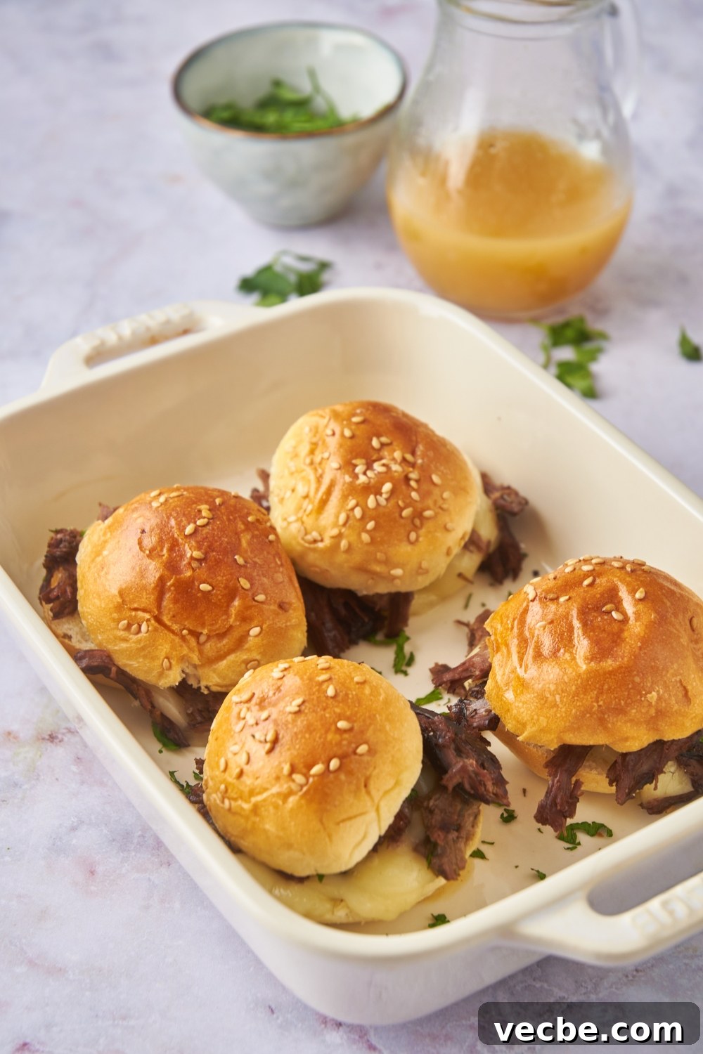 Fall-Apart Slow Cooker Tri-Tip Recipe 4 Four mini tri tip sandwiches with cheese and fresh herbs in the sandwiches. Each sandwich is topped with a buttered poppyseed bun.