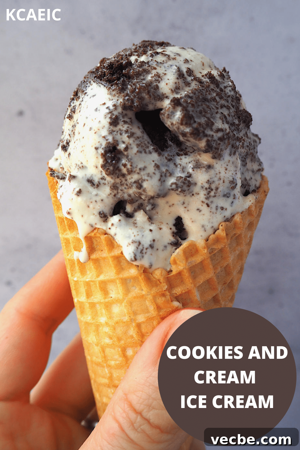Cookies and Cream Ice Cream Recipe 23 Close up of scoop of cookies and cream ice cream in a waffle cone being held, with text overlay, cookies and cream ice cream, KCAEIC.