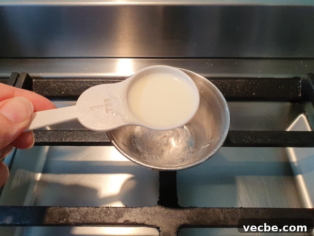 Cookies and Cream Ice Cream Recipe 4 adding milk to small bowl with tapioca starch in it to make a slurry.