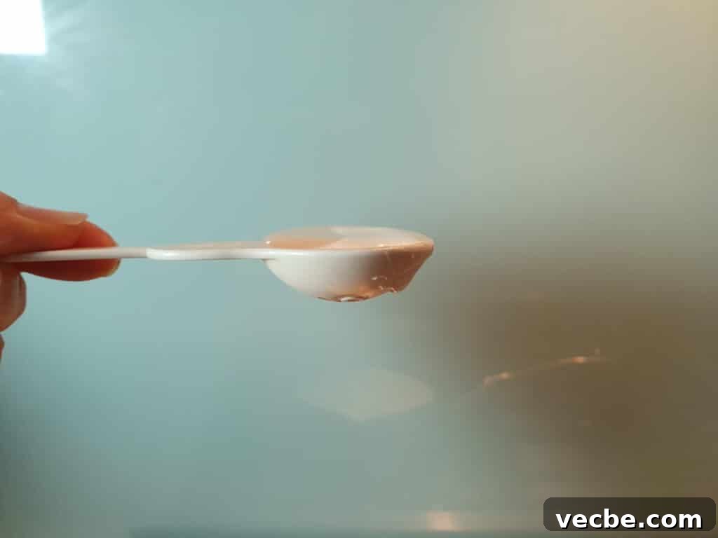 Cookies and Cream Ice Cream Recipe 5 side view of half table spoon measure showing flat table spoon of glucose syrup measured out.