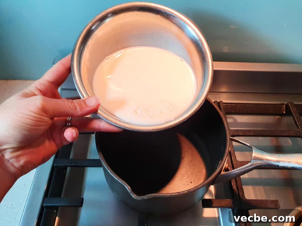 Cookies and Cream Ice Cream Recipe 6 adding milk to pot on stove.