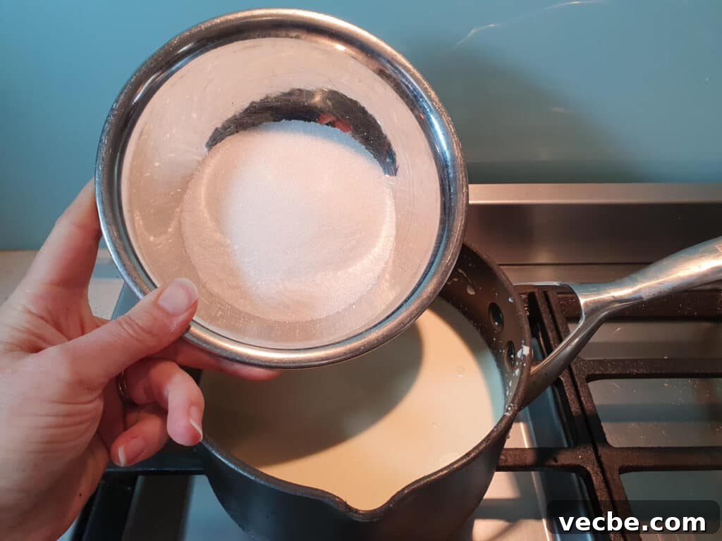 Cookies and Cream Ice Cream Recipe 8 adding sugar to ice cream mix in pot on stove.