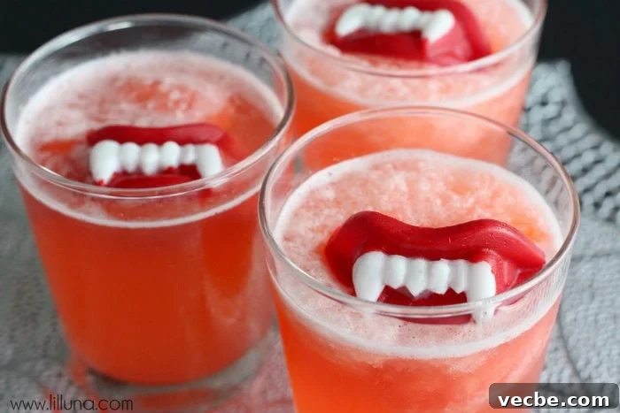 Slushy punch is fruity and fizzy and perfect for any occasion. Adding wax fangs make it a Halloween must! Halloween Slushy Punch Recipe with Wax Lips in a glass