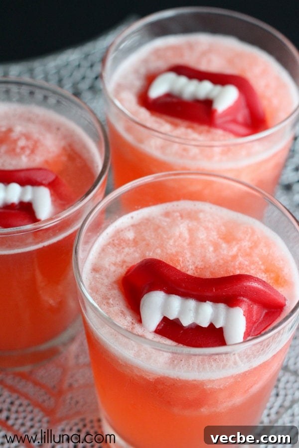 Slushy punch is fruity and fizzy and perfect for any occasion. Adding wax fangs make it a Halloween must! Halloween Slushy Punch in glasses with wax lips inside