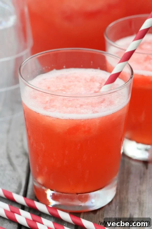Slushy punch is fruity and fizzy and perfect for any occasion. Adding wax fangs make it a Halloween must! Lemon and lime Slushy Punch with strawberry and pineapple flavor in a glass