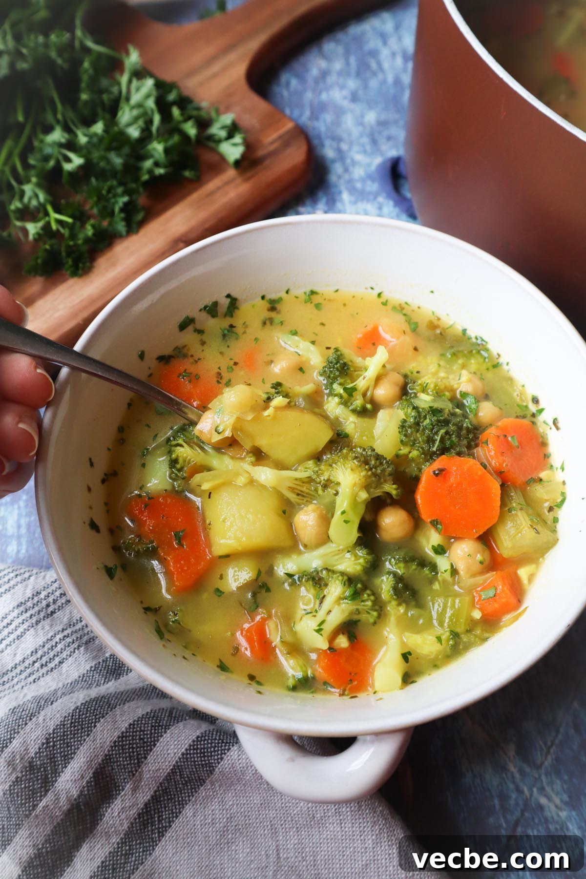 Creamy Vegan Chickpea Broccoli Soup 7 spoon in white bowl with broccoli chickpea soup