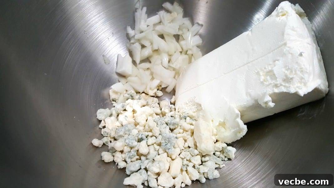 Creamy 4-Ingredient Beer Cheese Dip Recipe 3 onions, blue cheese and cream cheese in a bowl.