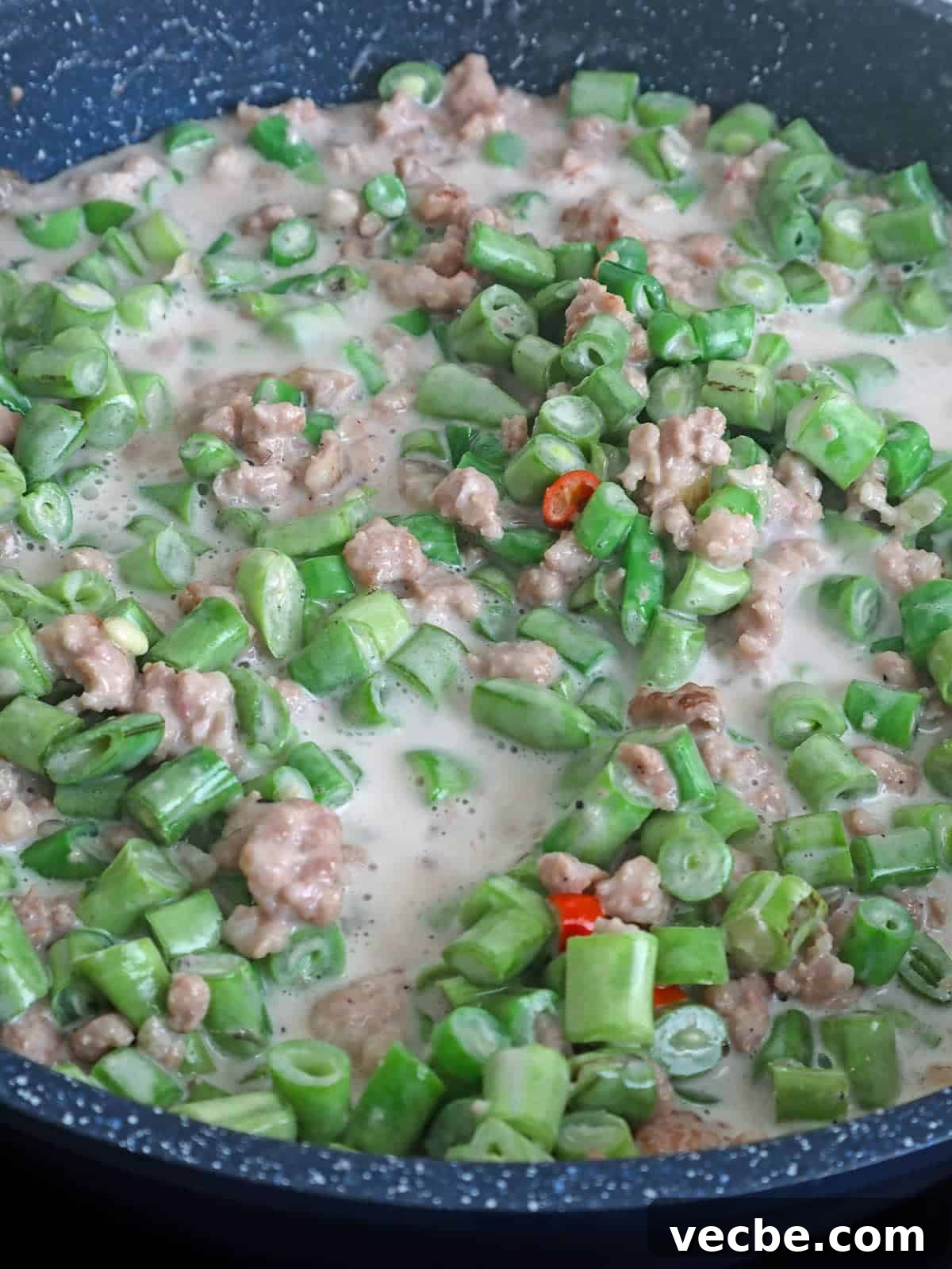 Gising Gising Filipino Green Beans in Spicy Coconut Sauce 4 cooking green beans with coconut milk and ground pork in a skillet