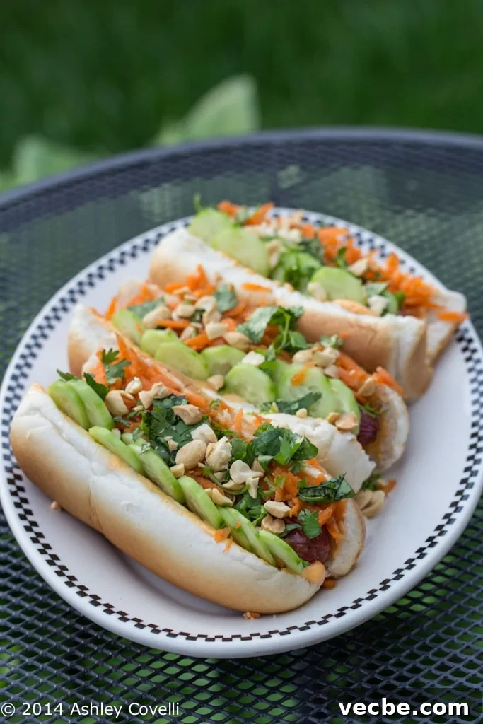 Hot dogs on a plate with various banh mi toppings.