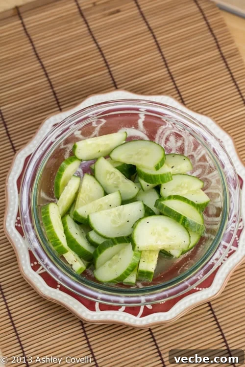 Overhead view of a bowl of sweet and sour cucumber salad.