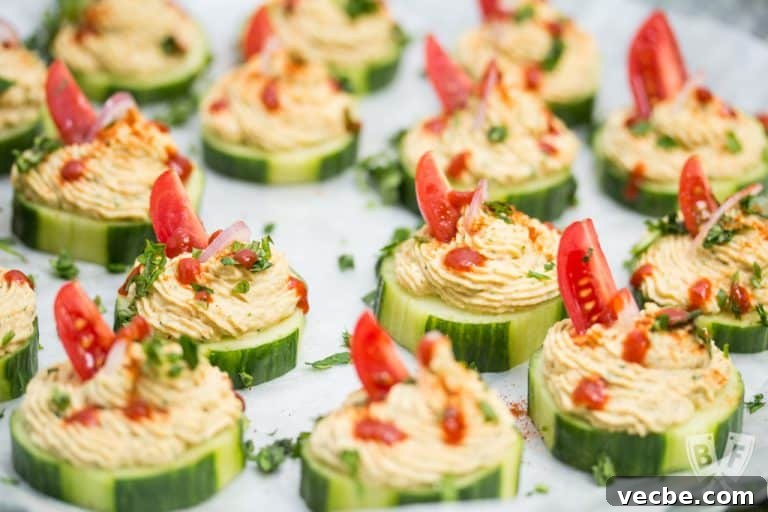 Close up of a few cucumber slices topped with a spiced chickpea purée.