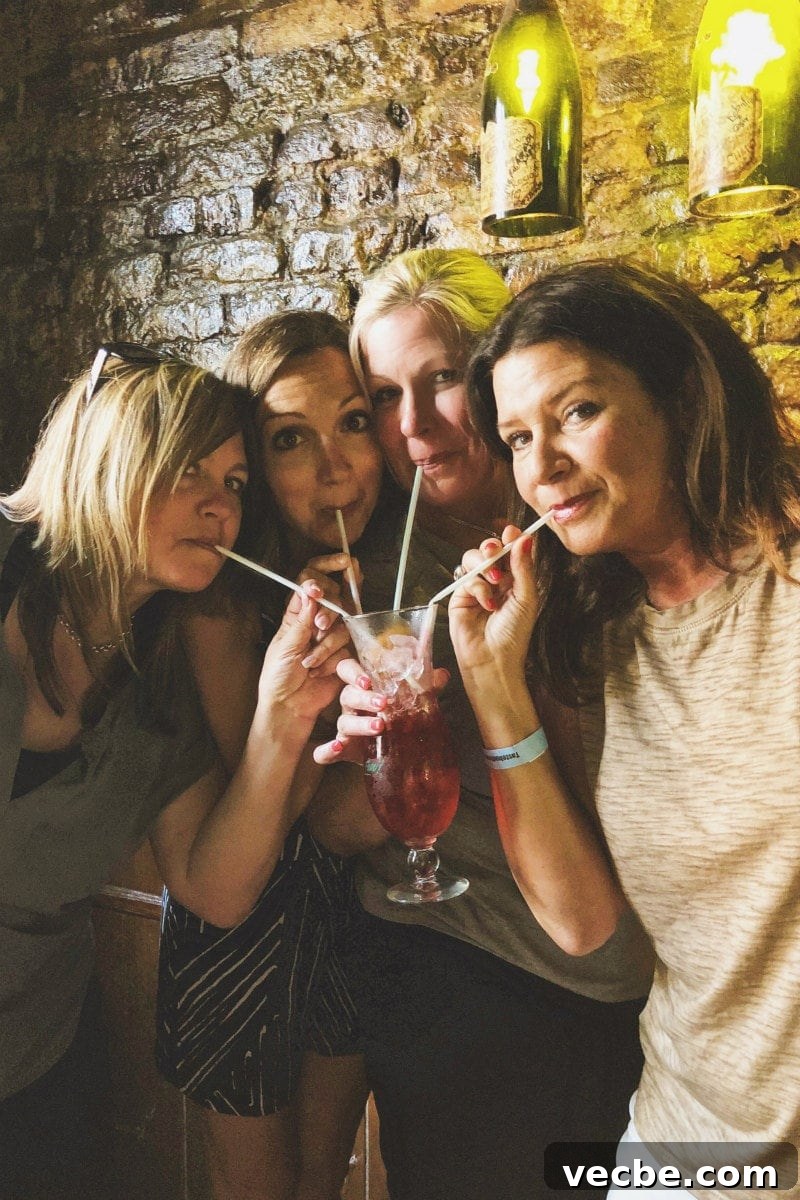 Sharing a Hurricane Cocktail four girls sharing a hurricane cocktail with straws