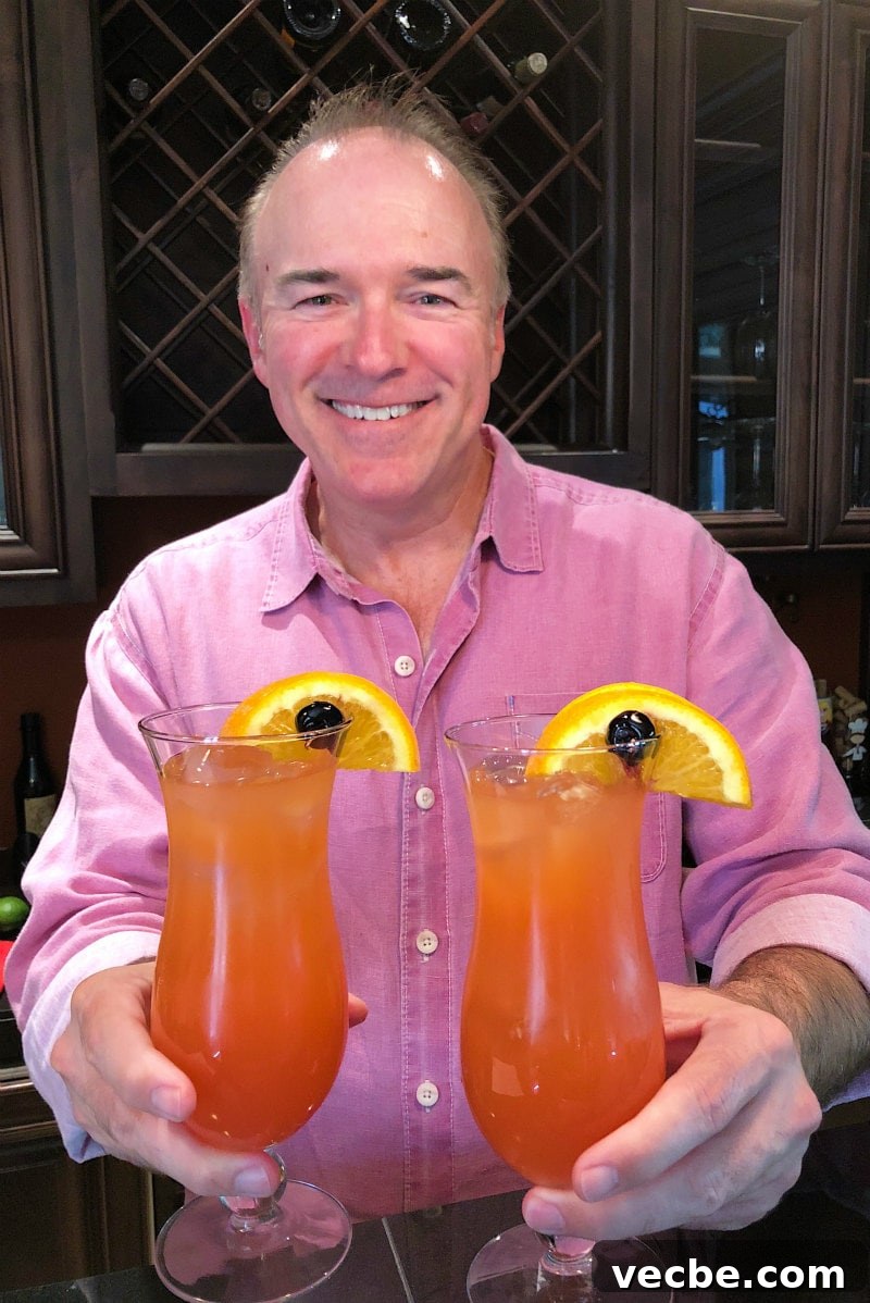 Hurricane Cocktails man in a pink shirt holding two hurricane cocktails