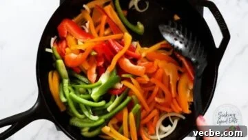 Authentic Cajun Sausage and Peppers Recipe 7 Cooking sausage and peppers in a cast iron skillet