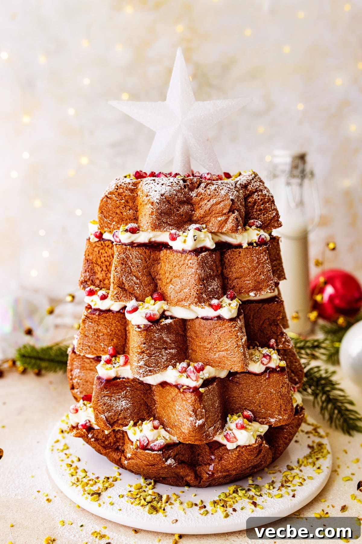 65+ Christmas Dessert Recipes Your Guests Will Love 17 Pandoro Christmas Tree Cake decorated with pomegranate seeds and a white star on top.