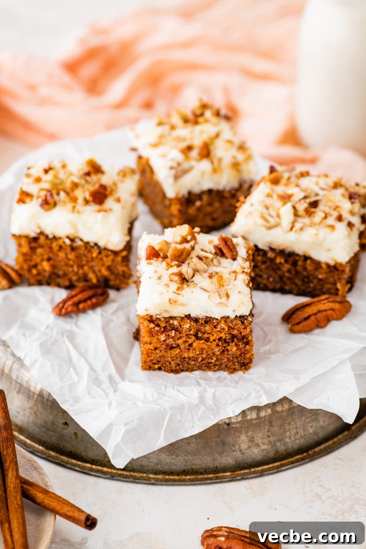 65+ Christmas Dessert Recipes Your Guests Will Love 20 a tray of square slices of carrot cake with some pecans on the side.